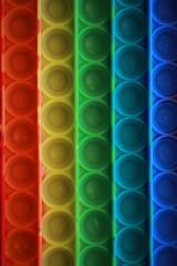 Colorful Rainbow Pop-It Fidget Toy Background with Red, Yellow, Green, Blue Rows - Stress Relief and Sensory Play