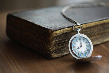 Vintage Pocket Watch Resting on Antique Book on Wooden Table - Timeless Elegance in Classic...