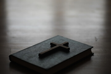Old Bible with Wooden Cross on a Wooden Table in Minimalist Setting