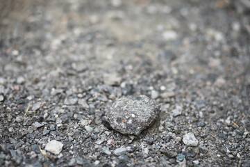 Close-Up of a Rough Gravel Surface with a Single Stone for Construction and Roadwork Themes