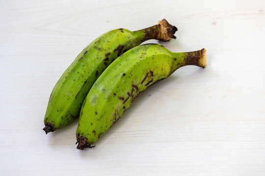 Two fresh green banana or raw banana on wooden background.
