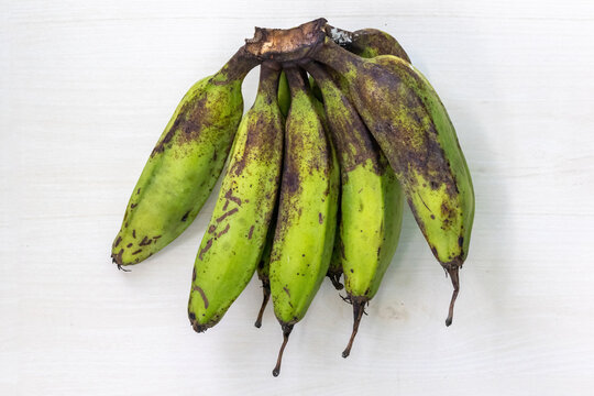 Bunch of fresh green banana or raw banana on light wooden surface. Top view.