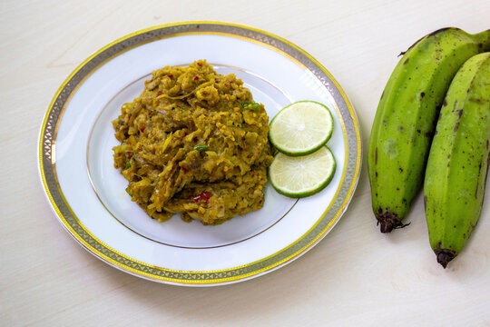 Traditional Bengali food Kacha kola bhorta or kachkola bharta served in white plate on wooden background. Delicious Bangladesh food.