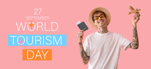 Happy young man with passport, ticket and wooden plane on pink background