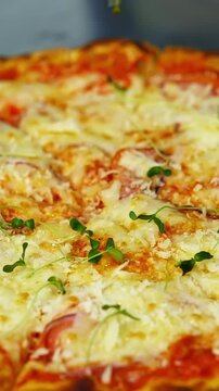 Cook decorates ready pizza. Chef's hand in glove is sprinking fresh green sprouts on a baked pizza in a restaurant. Close-up. Vertical video