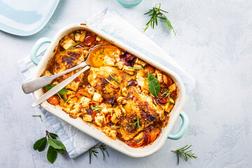 Baked chicken pieces with vegetable, tomato and feta cheese, casserole dish