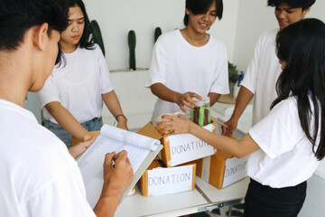 Obraz premium Preparation for Charity Event. Humanitarian Activist Packing Food for Donation.