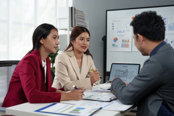 Asian business people team analyzing and brainstorming using calculators. Hand-pointing financial data on the sheet. Graph Chart showing earnings. growth teamwork process concept.
