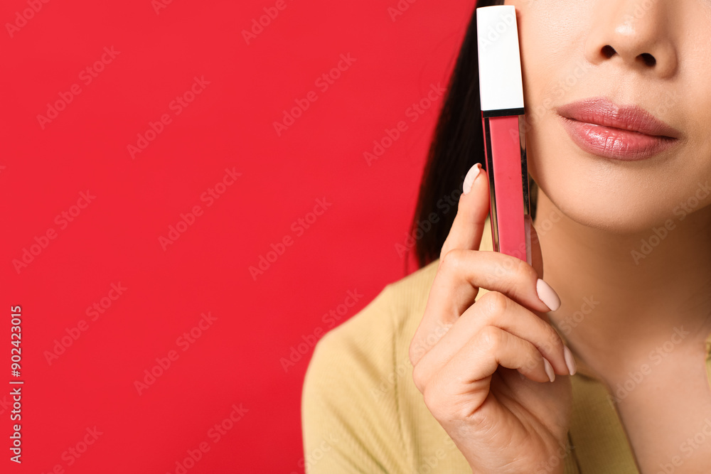 Sticker beautiful asian woman with liquid lipstick on red background, closeup