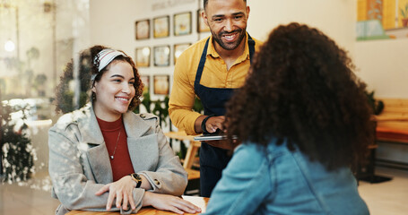 Coffee shop, women and waiter order with tablet, conversation and customer service at restaurant....