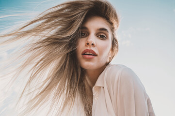 portrait of Beautiful blonde woman in water in river on sunset in golden sun beams. scoop up water in palms simple natural fairytale photography	