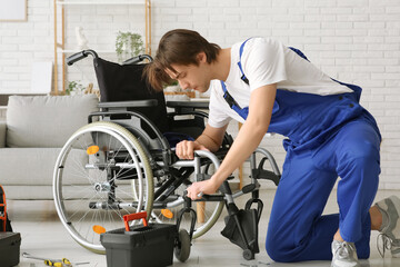 Male worker with wrench repairing wheelchair in room