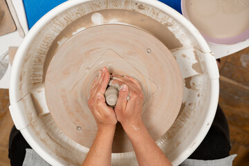 Forming the proper size and shape of pottery with increasing speed of a pottery wheel. Making a bowl on a pottery wheel with your own hands.