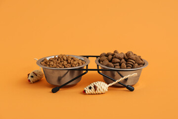 Bowls with different dry pet food on brown background