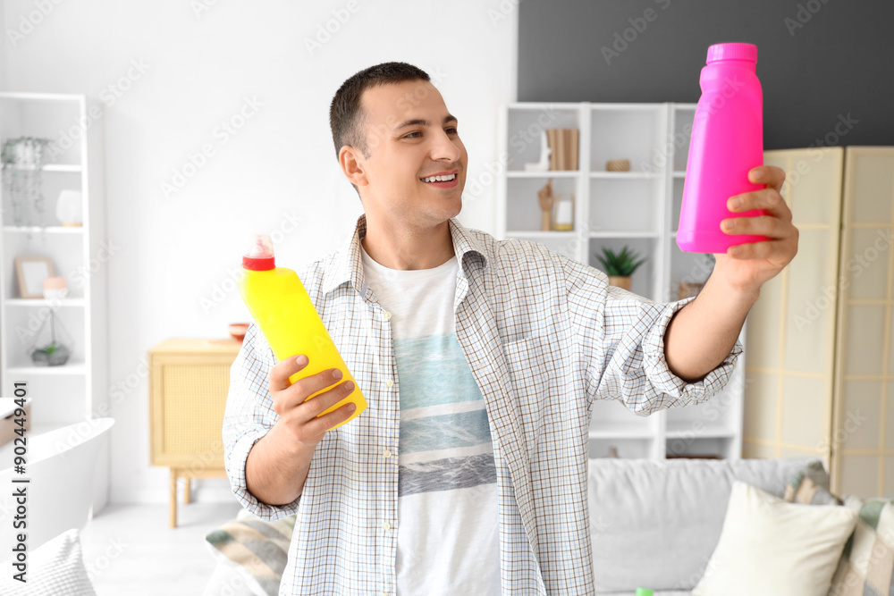 Canvas Prints young man with bottles of detergent at home