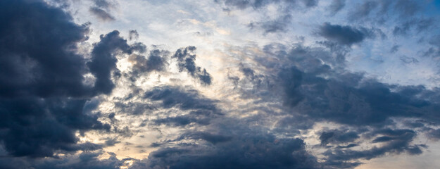 Dark blue clouds in the sky illuminated by the evening sun
