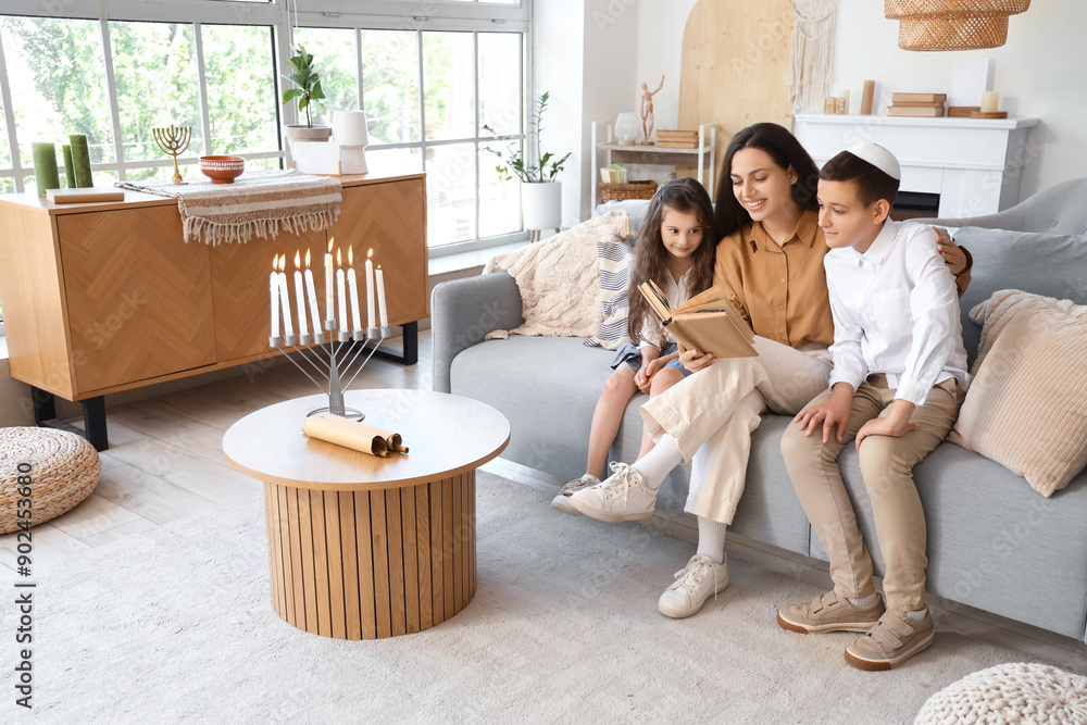 Sticker Happy Jewish mother with her little children reading book on sofa at home