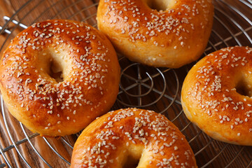 Stand with tasty bagels on wooden background, closeup