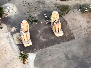 Soar above Luxor and marvel at the grandeur of the Memnon Colossi. This aerial view offers a unique perspective of these ancient statues, guardians of the Nile Valley.