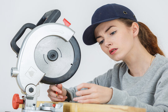 female carpenter using circular saw for wood