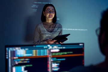asian woman developers collaborating on a coding project, with one member presentation at code...