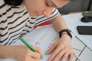 Woman hands writing, drawing with pencil close up. On German 