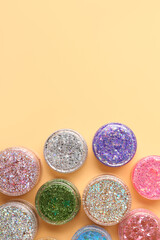 Jars of glitter on beige background
