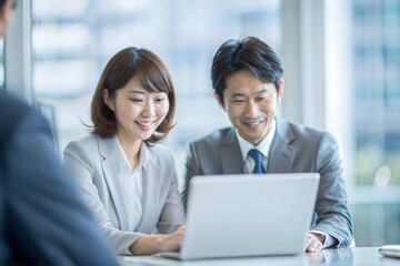 Fototapeta premium ラップトップで共同作業する日本人の同僚 
