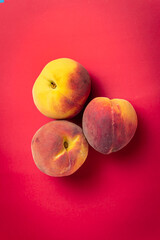 Peach fruit on red background 