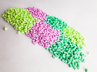 Masterbatch granules with pastel colors on a white background. Color pigment carrier polymers in...