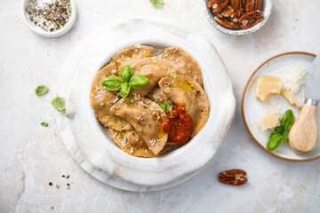 Homemade ravioli with red pesto and nuts