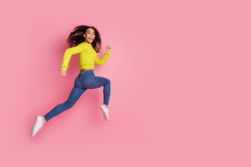 Full length photo of sporty youth funny girl wearing green sweater and jeans jumping running in...