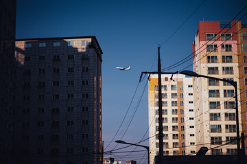 건물 사이로 비행하는 항공기