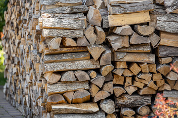 Background of stacked chopped wood logs. Pile of wood logs ready for winter. Wooden stumps, firewood stacked in heap