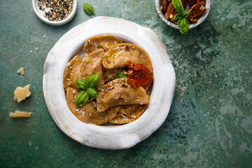 Homemade ravioli with red pesto and nuts