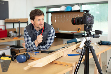 carpenter filming tutorial blog in a workshop