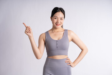 Portrait of Asian woman wearing sportswear, posing on white background