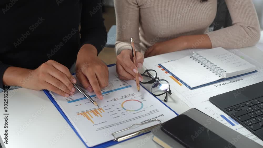 Poster teamwork of two businesswomen talking brainstorming and calculations with a calculator on assessment