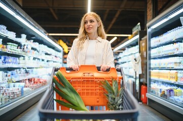 Young woman looking at product at grocery store. Costumer buying food at the market
