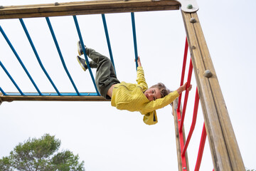 Child playing climbing on a playground structure