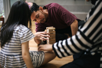 Happy Asian Family Playing Wooden Blocks Tower Together At Home