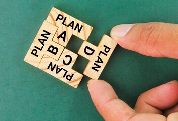 wooden puzzle with four plans a, b, c and d completed. finish the task. Business strategy, failure analysis and not giving up