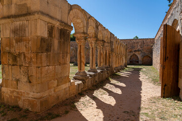 The historic cloister of Monasterio de San Juan de Duero in Soria, Spain, showcasing its iconic arches and ancient stone architecture on a bright sunny day