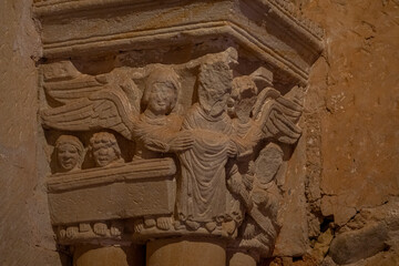Close-up of intricate sculptures on a column at Monasterio de San Juan de Duero in Soria, Spain. The carvings depict various figures and scenes, showcasing exceptional medieval artistry.