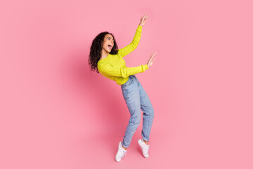 Photo portrait of teenager girl wavy brunette curly hair have fun dancing at discotheque enjoying music rhythm isolated on pink color background