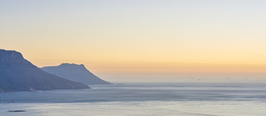 Mountain, sunset and sea scenery with nature or horizon for peace, travel destination and holiday location. Seascape, sky and ocean water for vacation landscape, panorama or environment on coast