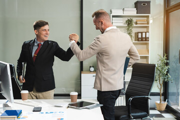business people holding each others wrists, join hands together, support and unity, team strength and power, colleagues involved in team building activity.