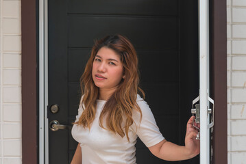 A woman opens the door of her apartment, disappointed and annoyed to see an unwelcome visitor.