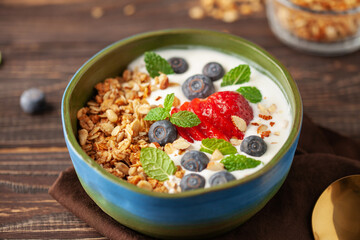 Homemade crispy granola, yogurt and berries in bowl on white background. Healthy breakfast.