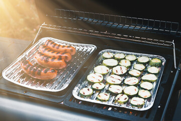Delicious barbecue dinner with grilled sausages and zucchini. Outdoors bbq